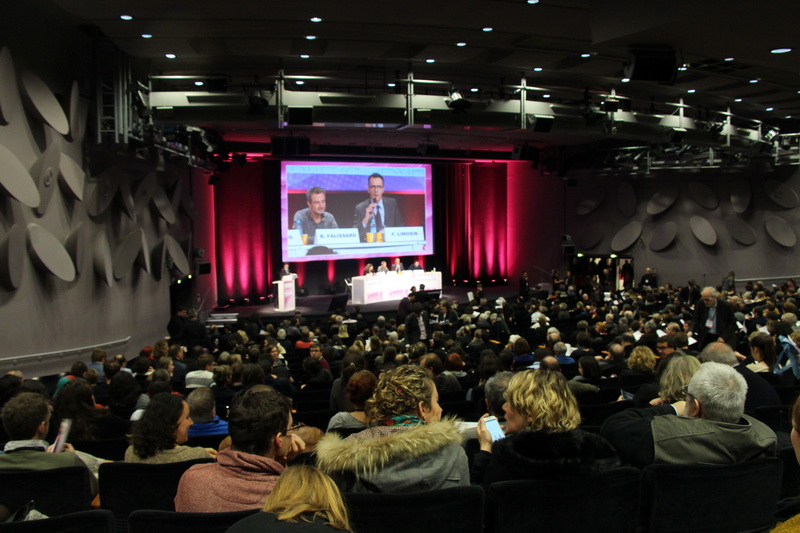 Photo du fond d'un auditorium où l'on voit le public et l'estrade avec un rétroprojecteur où l'on voit en close up les speakers - illustration EUROPA